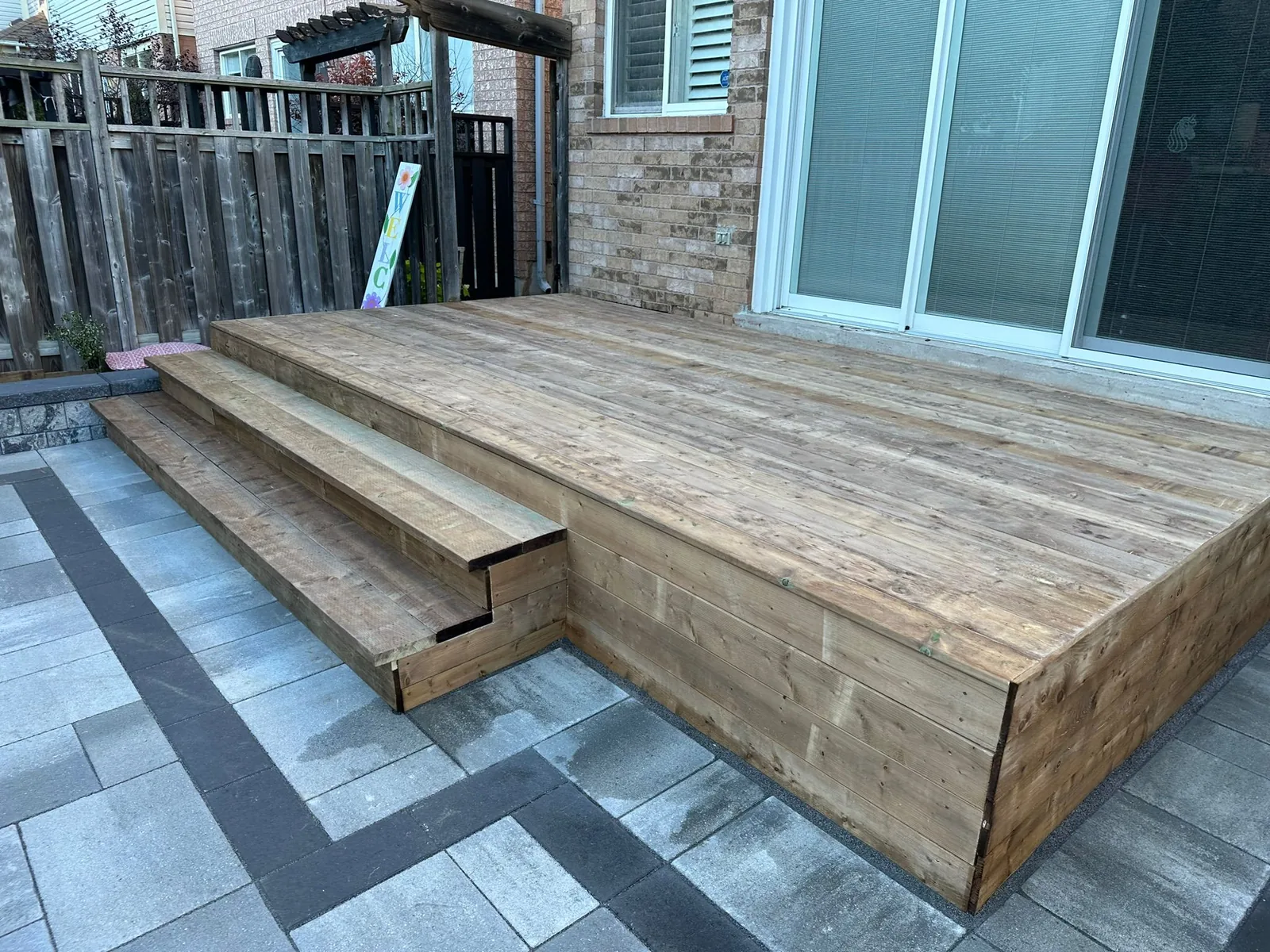 Private backyard retreat with pavers and fence
